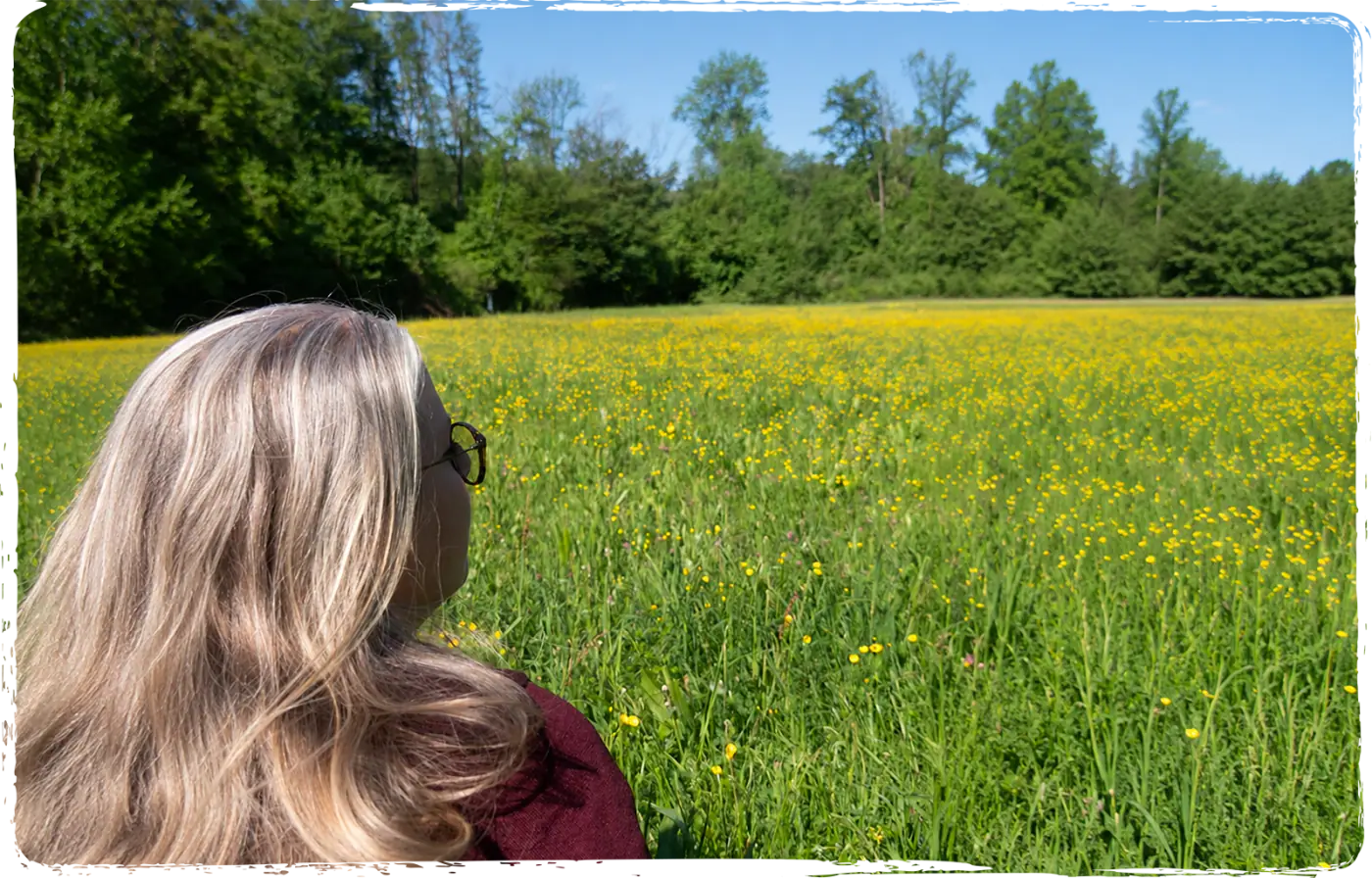 Raphaela blickt über eine Blumenwiese für Fernreiki und Lebensenergie